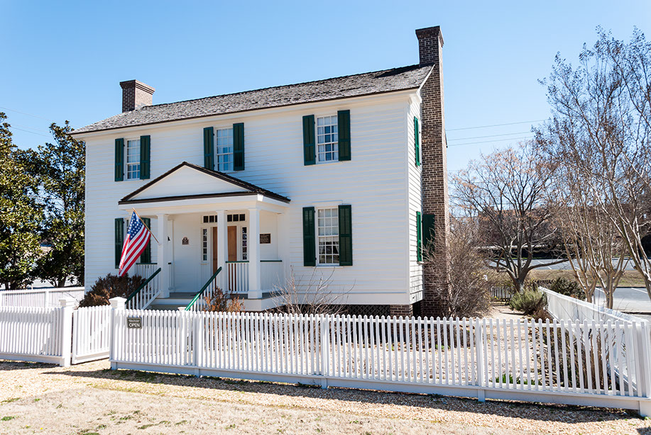beautiful white colonial home with an American flag