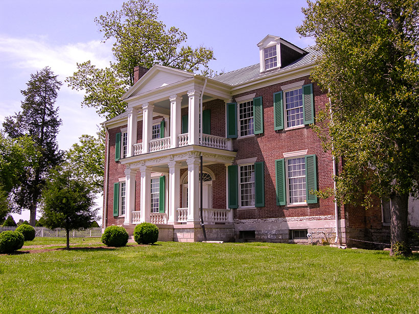 side view of a colonial home with a spacious yard